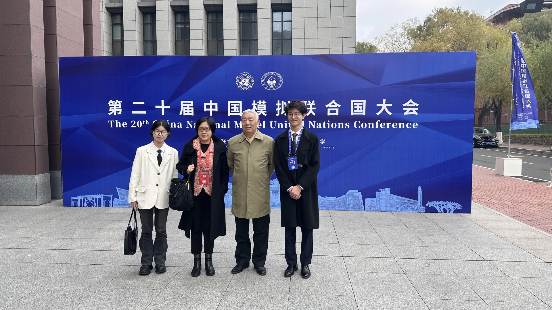郭子谦与同行人员在第二十届中国模拟联合国大会背景板前合影