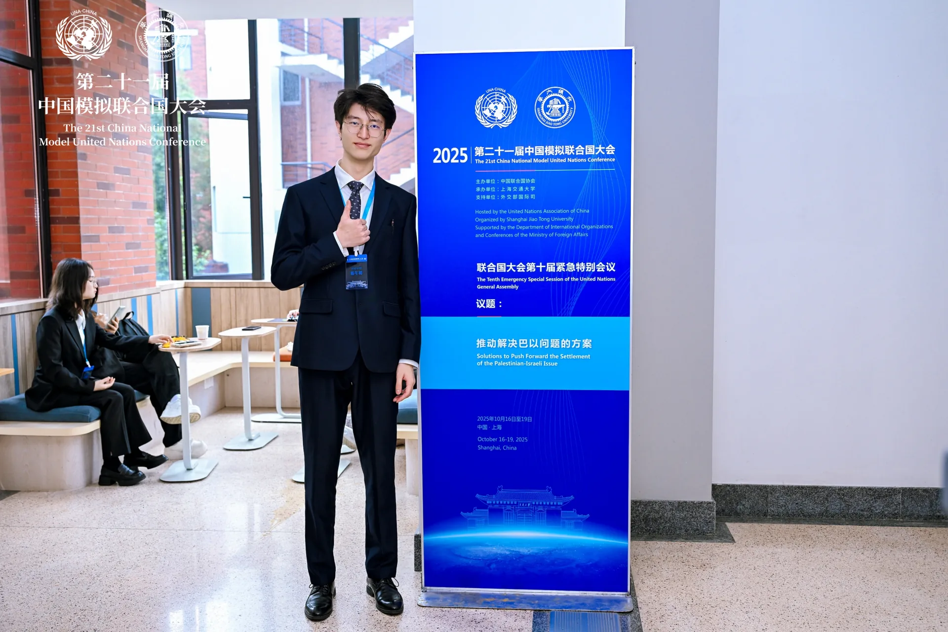 郭子谦在第二十一届中国模拟联合国大会活动立牌前留影