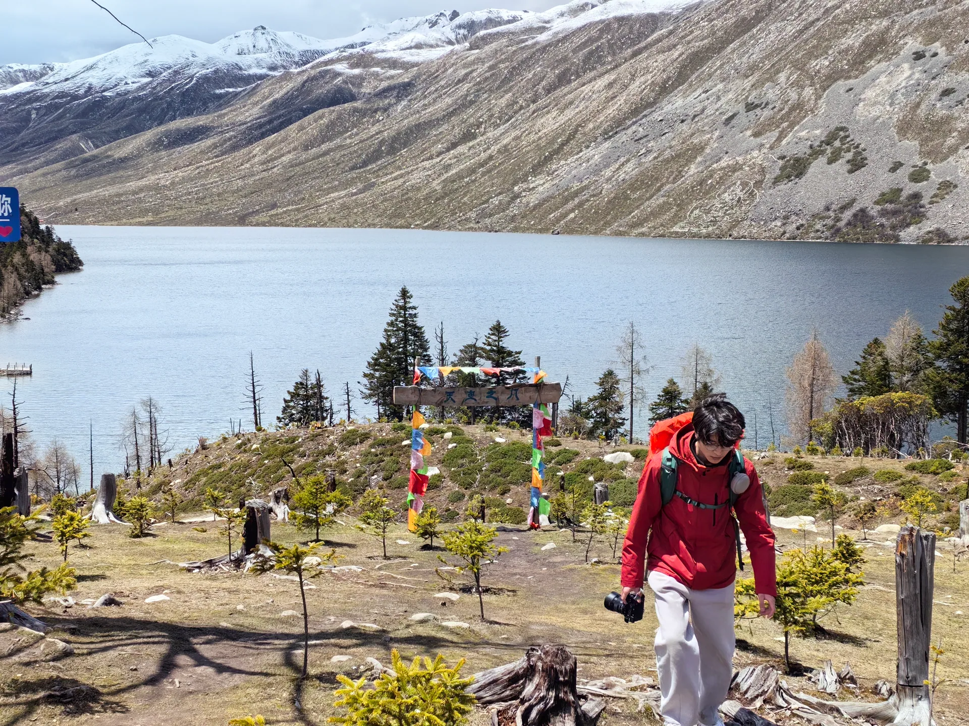 高山湖泊旁背着登山包前行的旅人