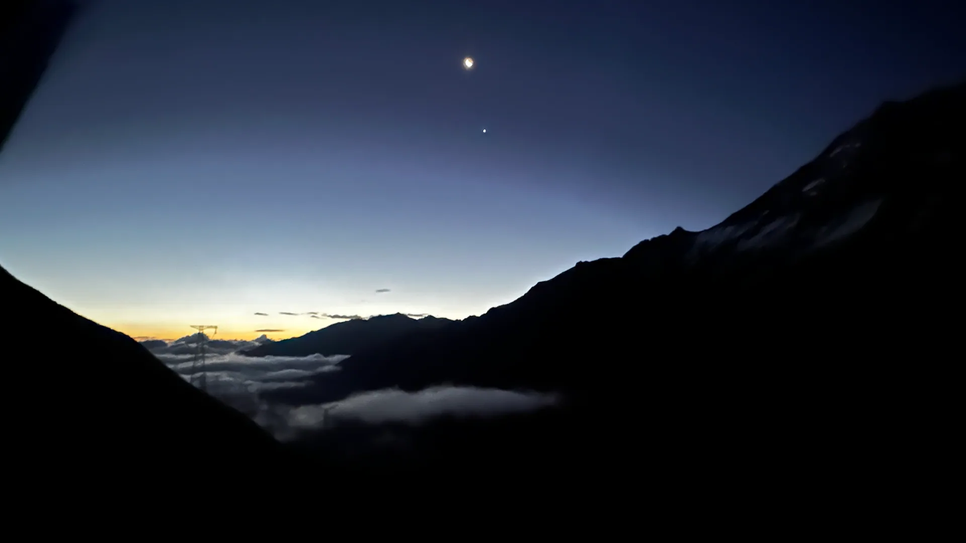 暮色山谷上空的月亮与星点