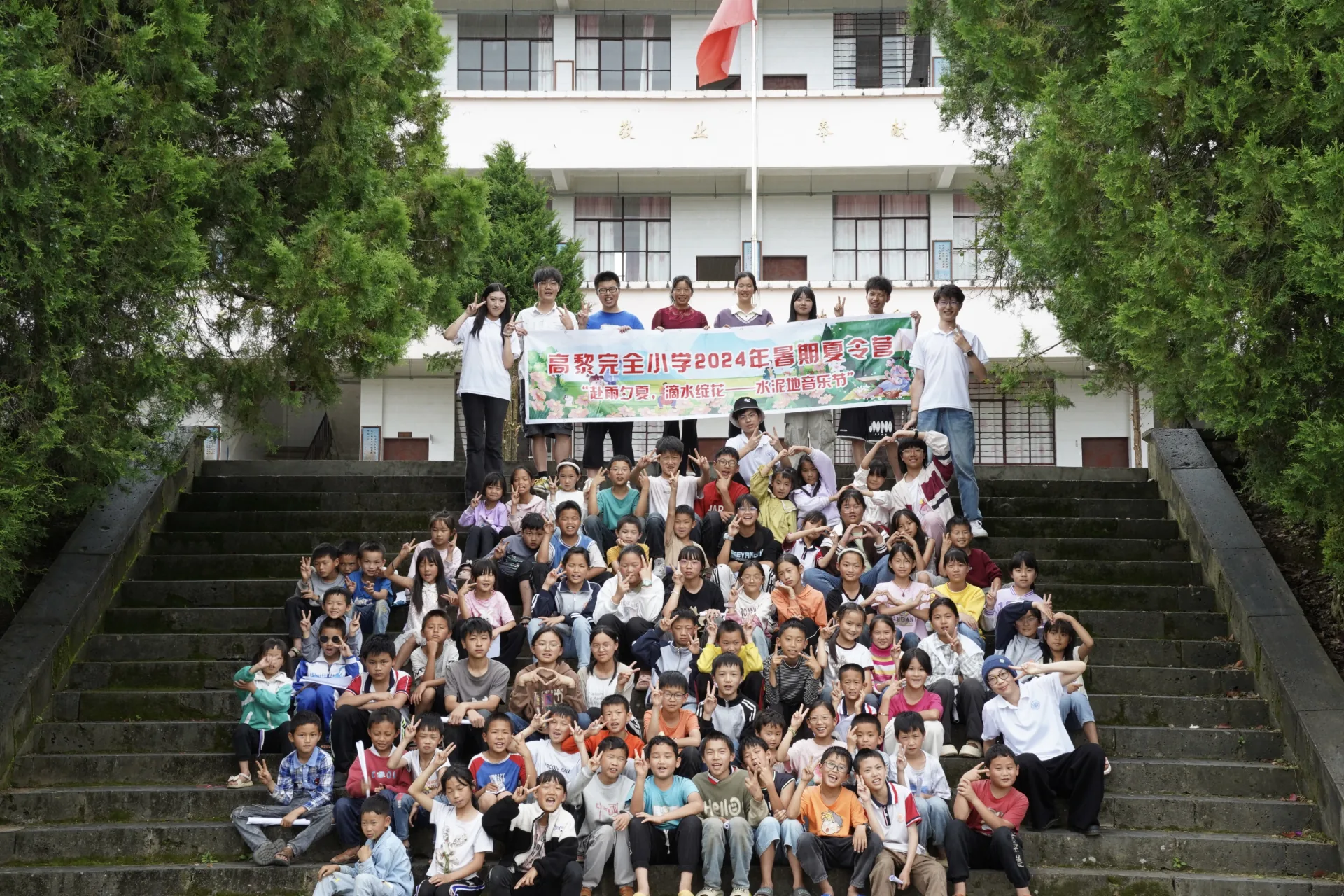 实践团队员与学生手持2024年暑期夏令营横幅合影