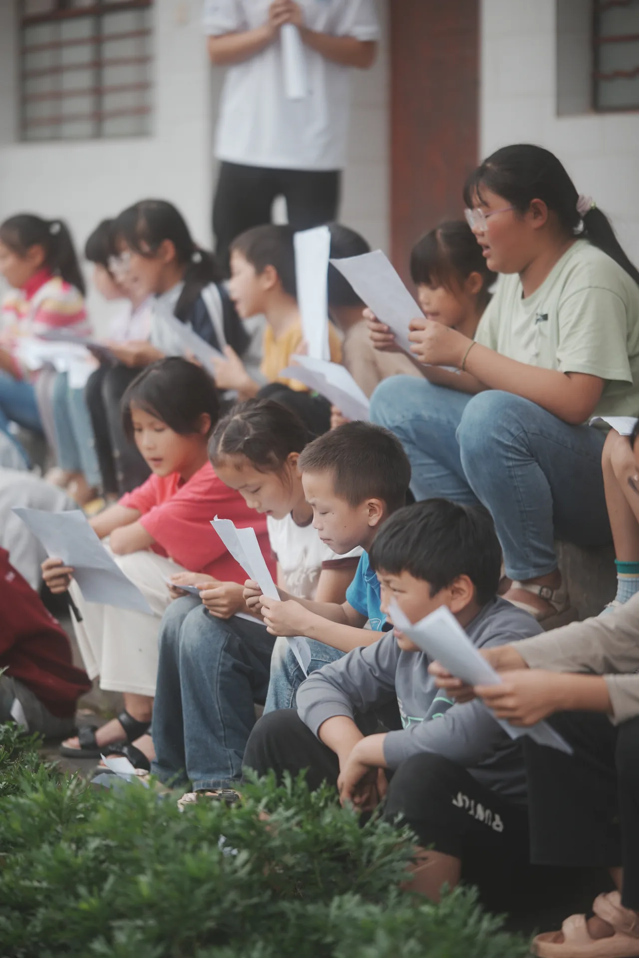 学生在校园台阶上集体朗读课堂材料