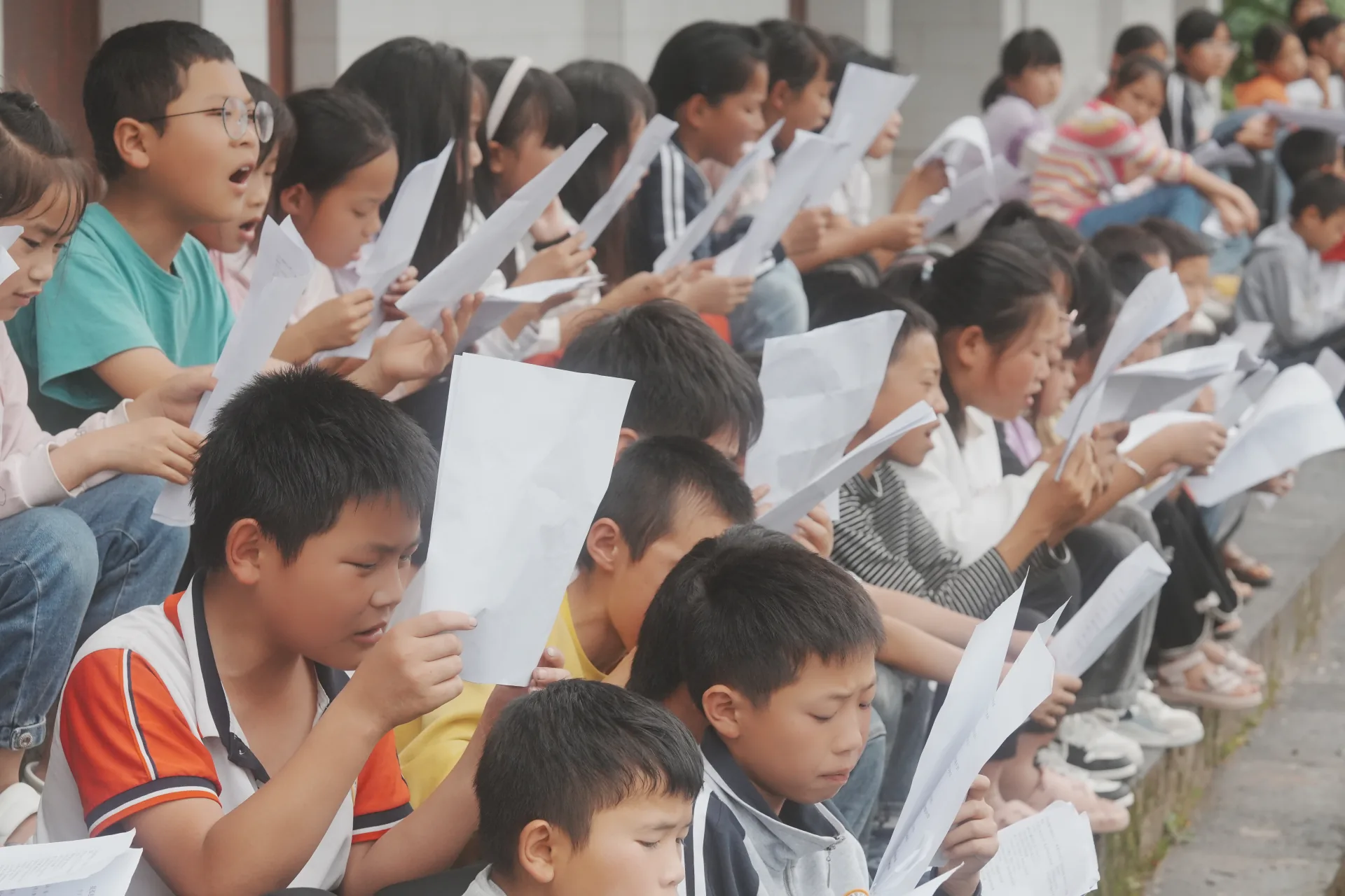 学生在校园台阶上参与集体朗读活动
