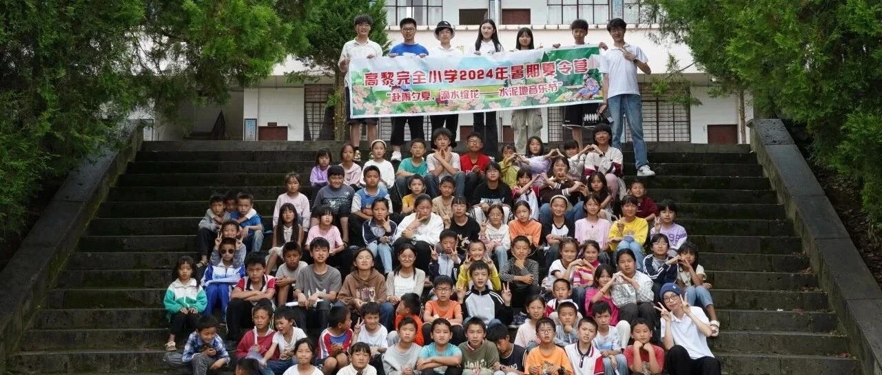 实践团队员与高黎贡完全小学学生在校园台阶上合影